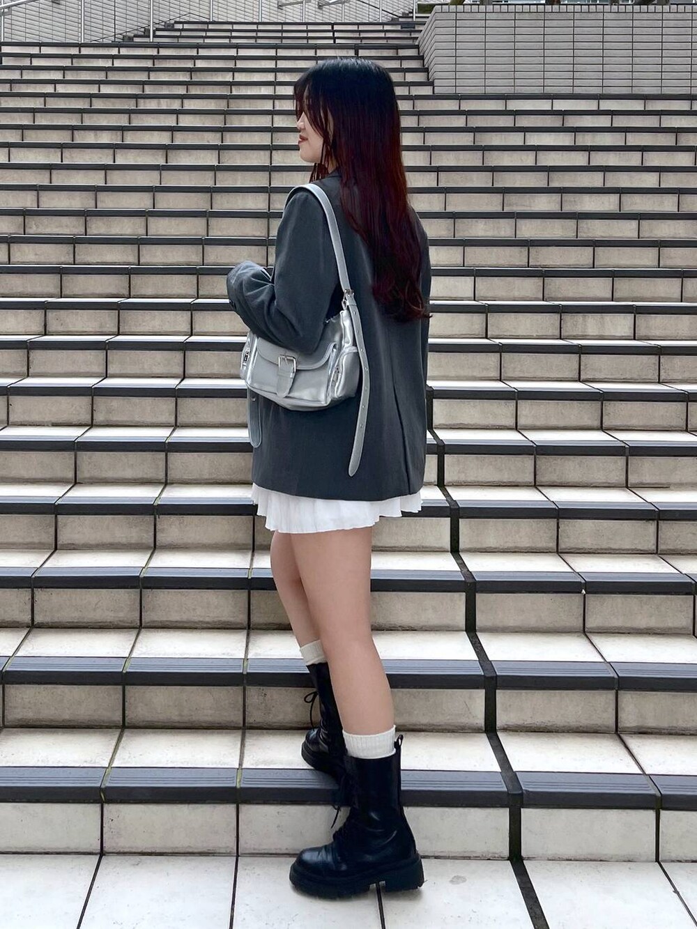 ホワイト系のキャミソール、ホワイト系のスカート、グレー系のテーラードジャケットを着用したレディースの春コーディネートの6枚目の写真