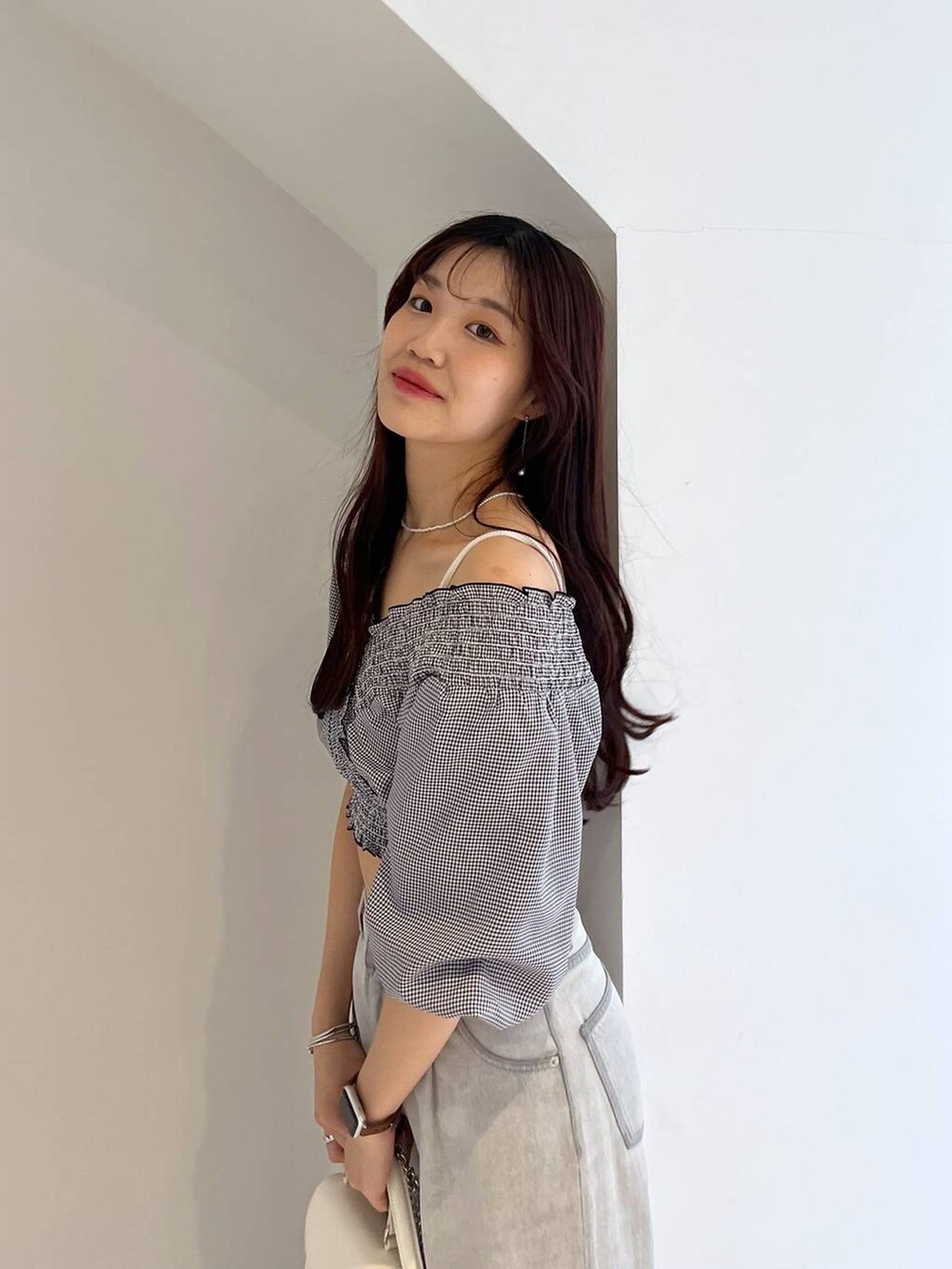 シルバー系のサンダル、ホワイト系のキャミソール、グレー系のデニムパンツを着用したレディースの春コーディネートの9枚目の写真