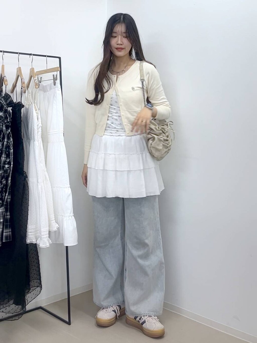 ホワイト系のキャミソール、ブルー系のデニムパンツ、ホワイト系のスカートを着用したレディースの春コーディネートの5枚目の写真