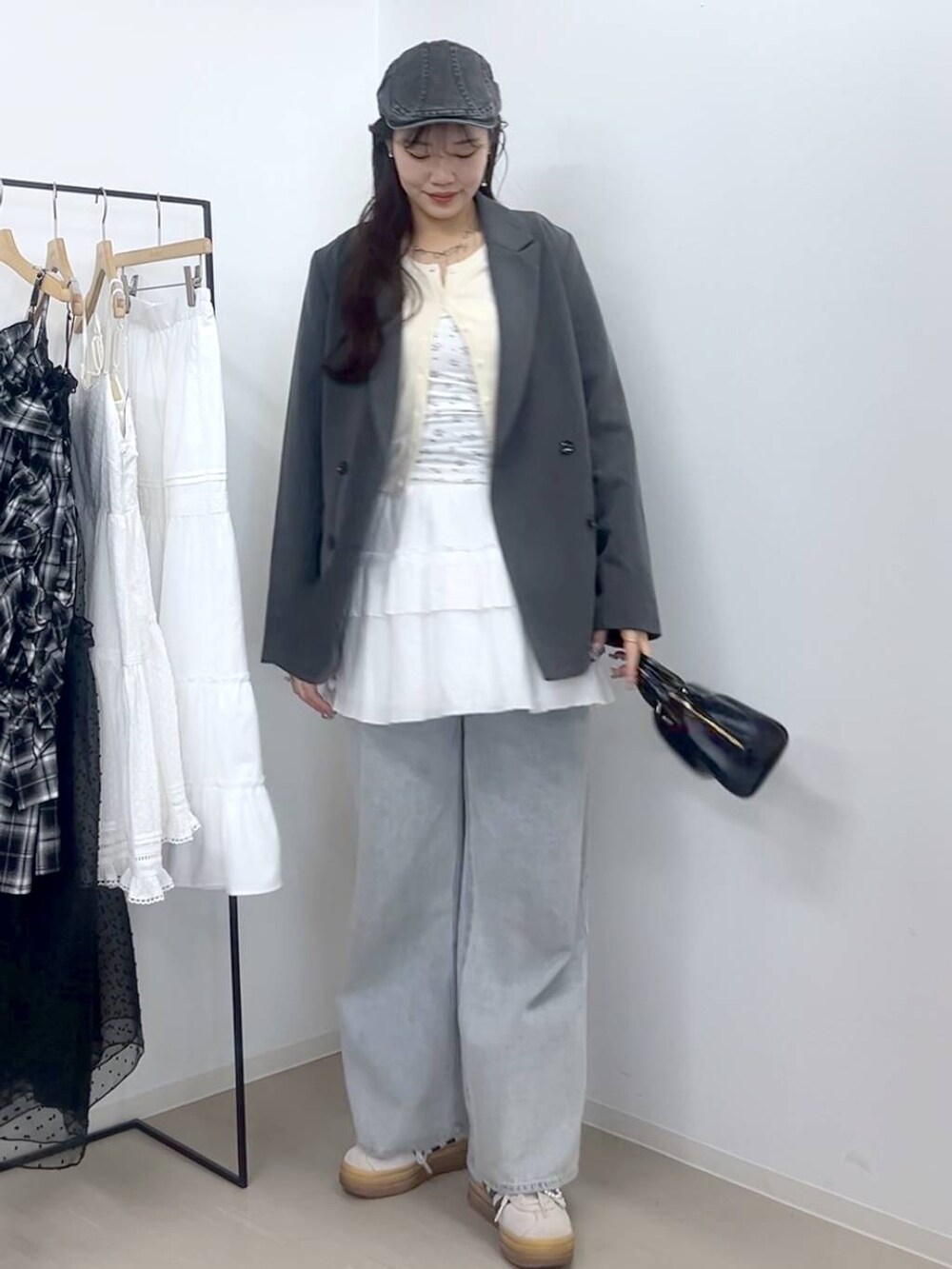 ホワイト系のキャミソール、ブルー系のデニムパンツ、ホワイト系のスカートを着用したレディースの春コーディネートの4枚目の写真