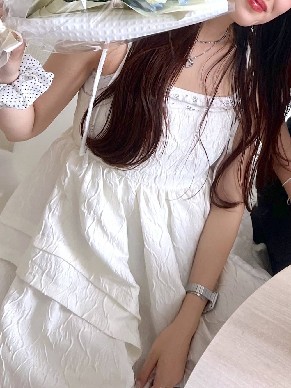 ホワイト系のワンピース、ホワイト系のカーディガン/ボレロ、ホワイト系のキャミソールを着用したレディースの春コーディネートの3枚目の写真