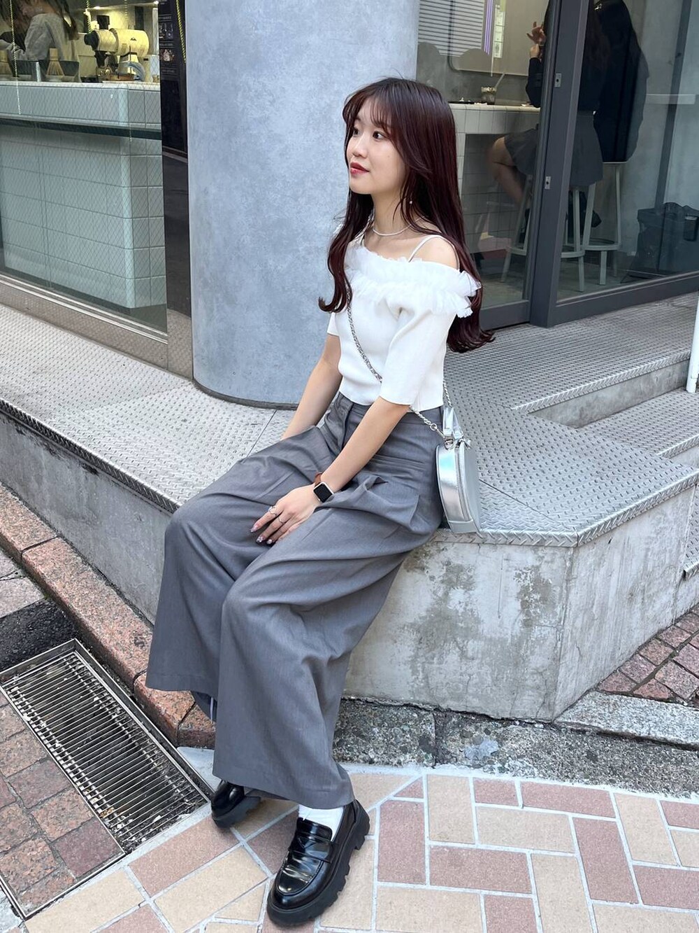 シルバー系のショルダーバッグ、グレー系のスラックス、ホワイト系のキャミソールを着用したレディースの春コーディネートの2枚目の写真