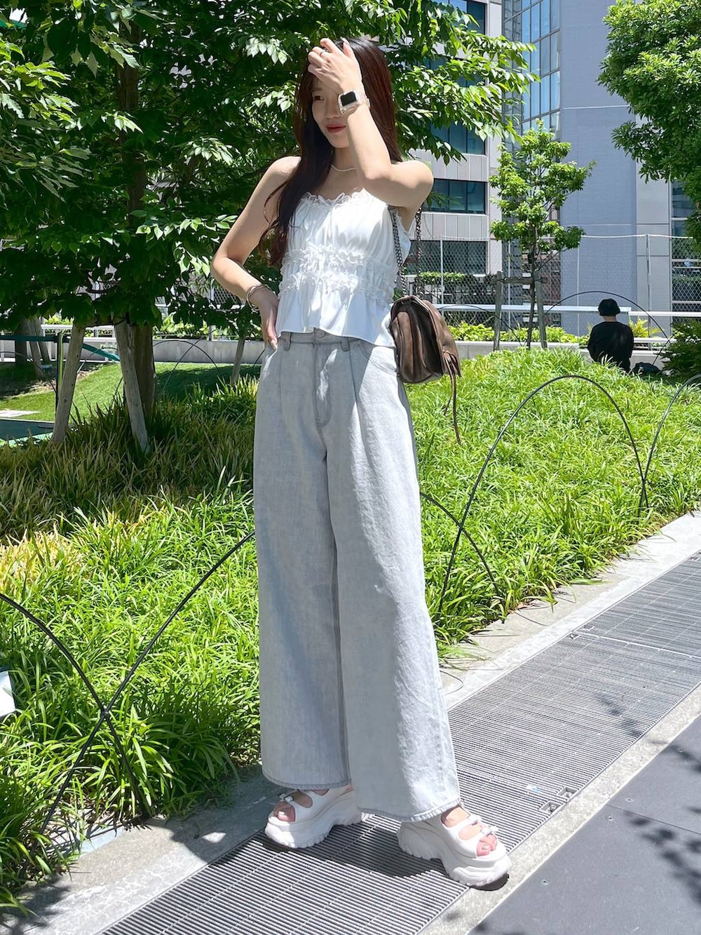 ホワイト系のキャミソール、グレー系のデニムパンツ、ホワイト系のサンダルを着用したレディースの夏コーディネートの4枚目の写真