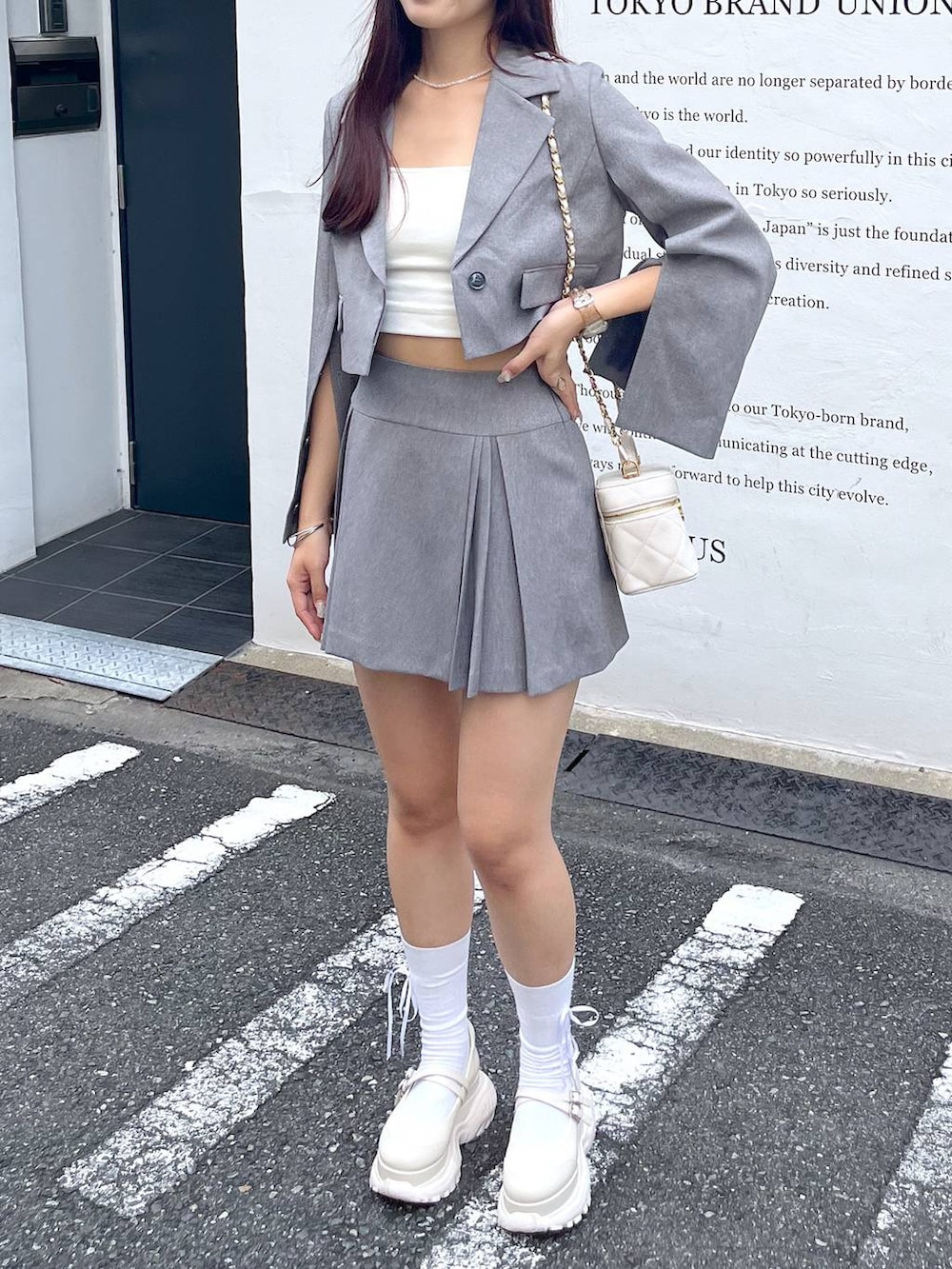 グレー系のテーラードジャケット、ホワイト系のショルダーバッグ、ホワイト系のキャミソールを着用したレディースの夏コーディネートの8枚目の写真