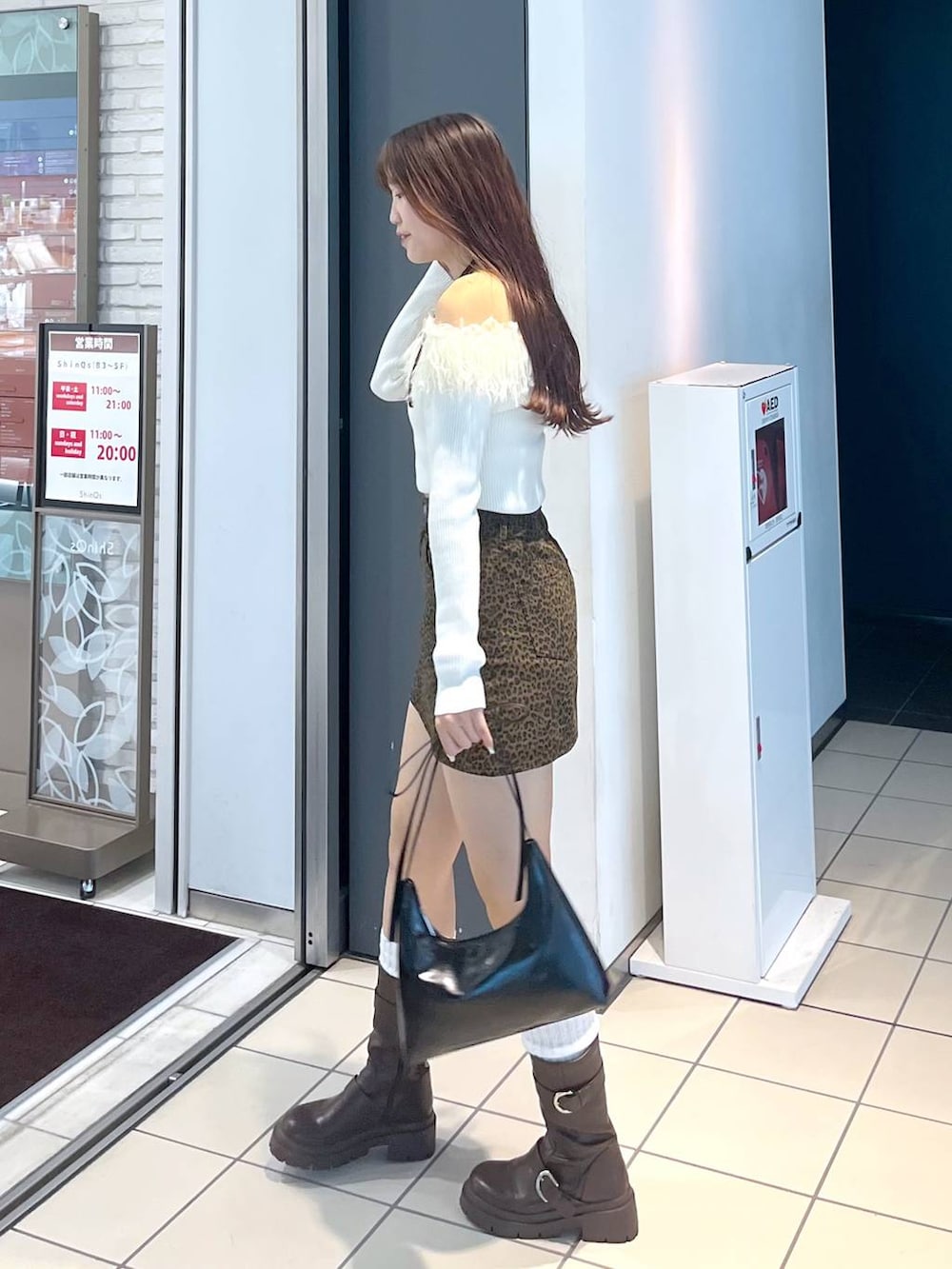 ブラウン系のブーツ、その他のスカート、ホワイト系のキャミソールを着用したレディースの秋コーディネートの3枚目の写真