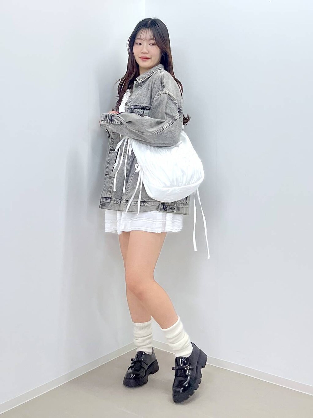 ホワイト系のTシャツ/カットソー、ブラック系のドレスシューズ、ホワイト系のニット/セーターを着用したレディースの冬コーディネートの3枚目の写真