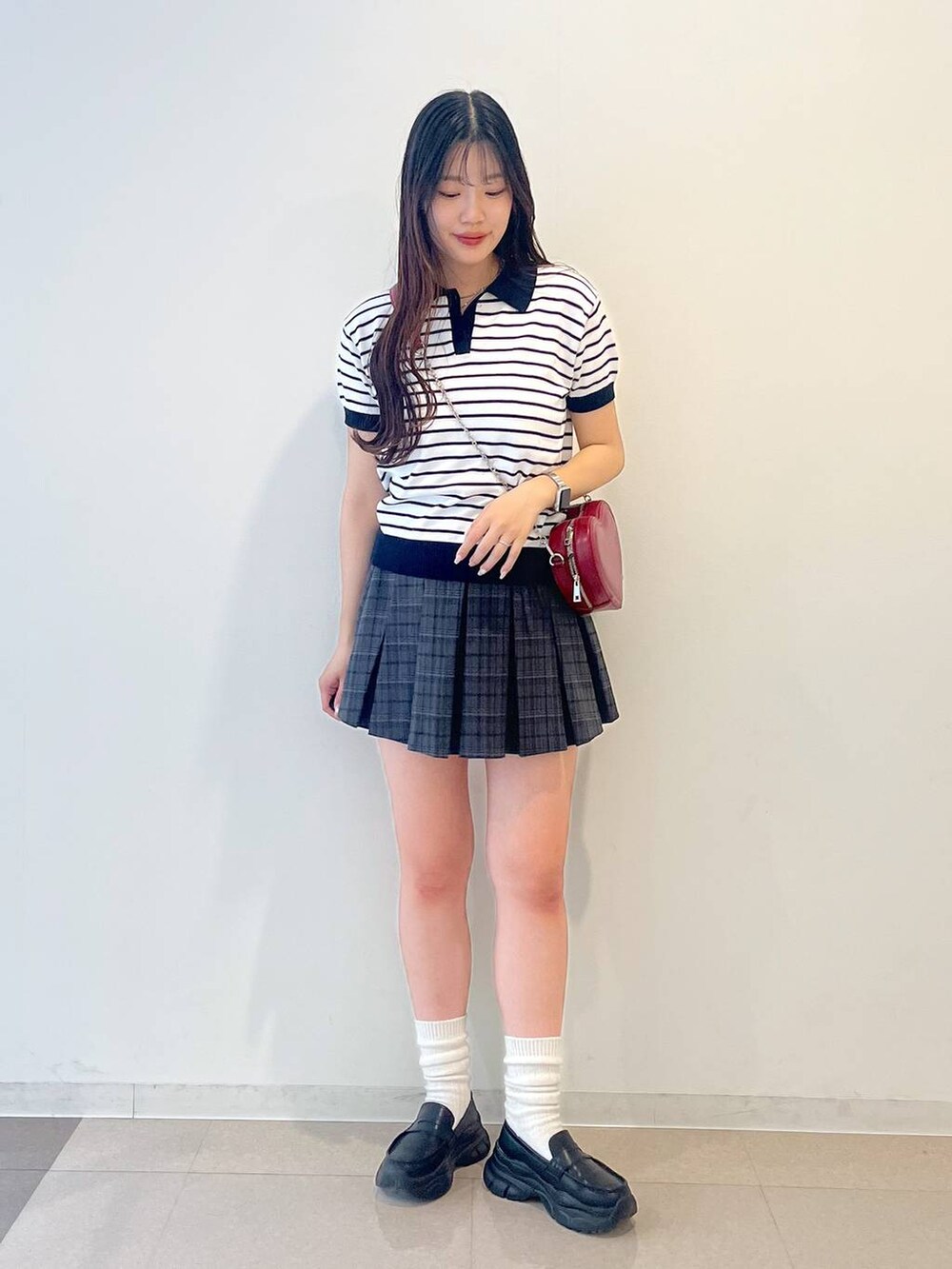 ホワイト系のキャミソール、ブラック系のローファー、グレー系のスカートを着用したレディースの春コーディネートの6枚目の写真