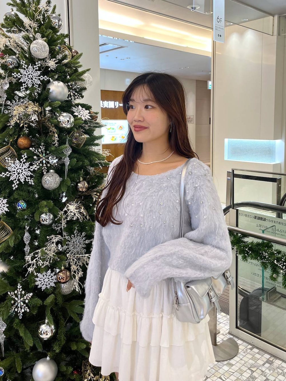 ホワイト系のTシャツ/カットソー、ブラック系のブーツ、シルバー系のショルダーバッグを着用したレディースの秋コーディネートの2枚目の写真