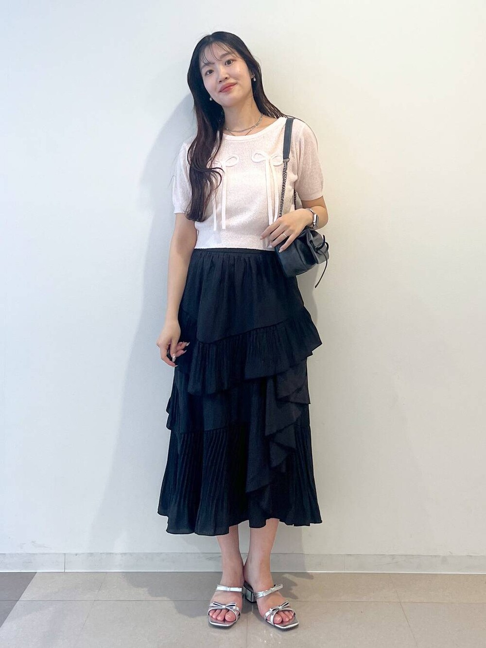 グレー系のショルダーバッグ、ホワイト系のキャミソール、ブラック系のスカートを着用したレディースの春コーディネートの2枚目の写真