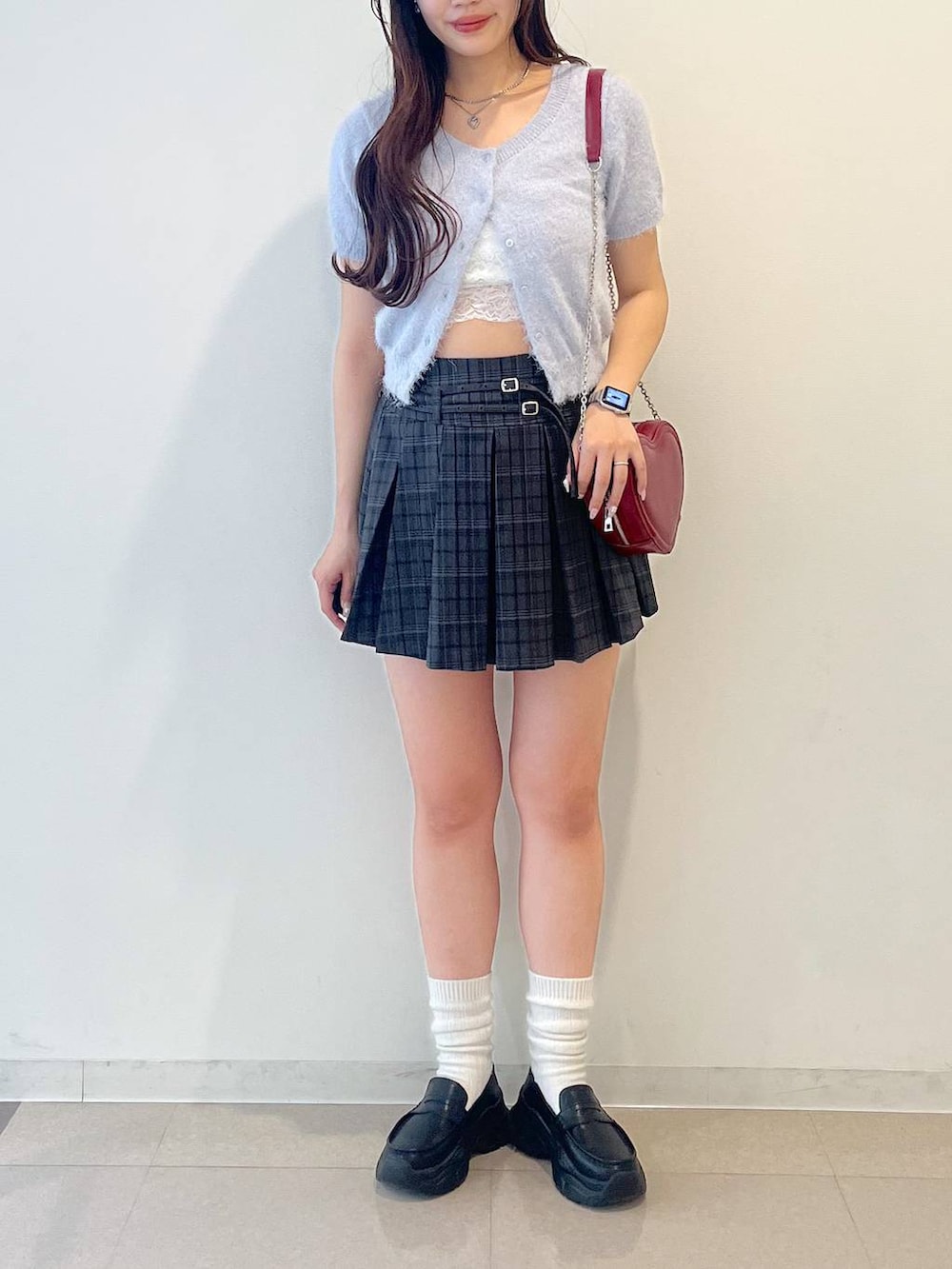 ブラック系のローファー、グレー系のスカート、レッド系のショルダーバッグを着用したレディースの春コーディネートの8枚目の写真