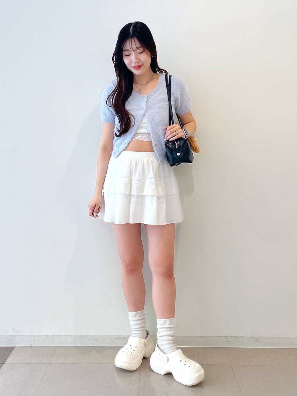ホワイト系のスカート、ブラック系のボストンバッグ、ホワイト系のキャミソールを着用したレディースの春コーディネートの6枚目の写真