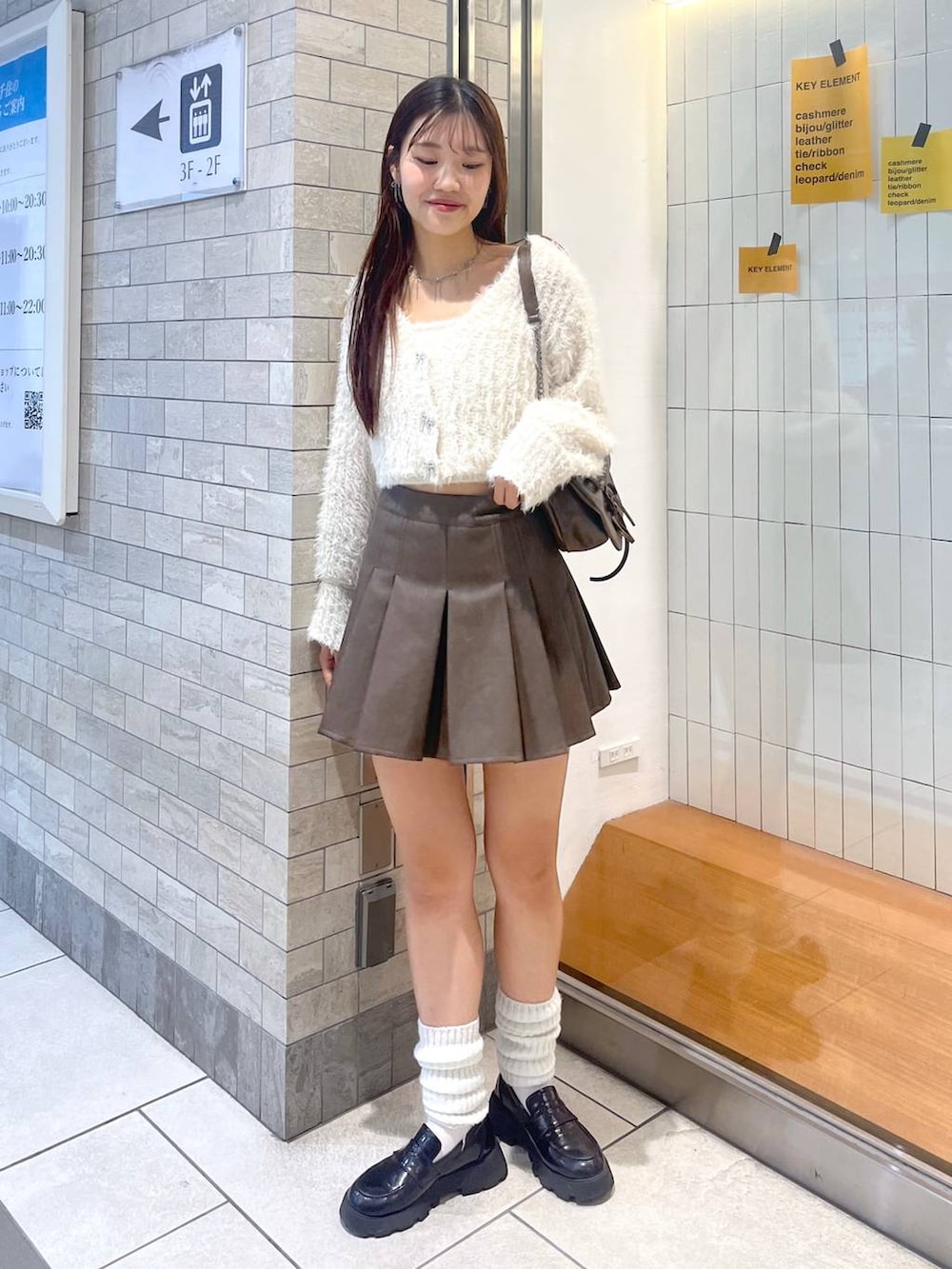 ブラウン系のショルダーバッグ、ホワイト系のアンサンブル、ホワイト系のキャミソールを着用したレディースの秋コーディネートの2枚目の写真