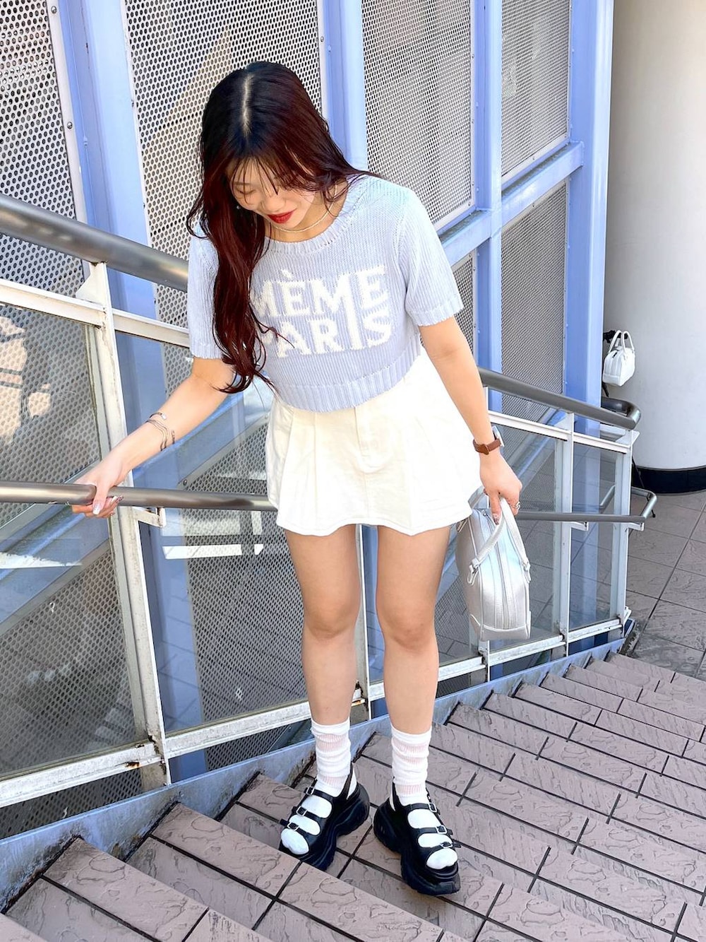 ブルー系のニット/セーター、ホワイト系のキャミソール、ブラック系のサンダルを着用したレディースの夏コーディネートの8枚目の写真