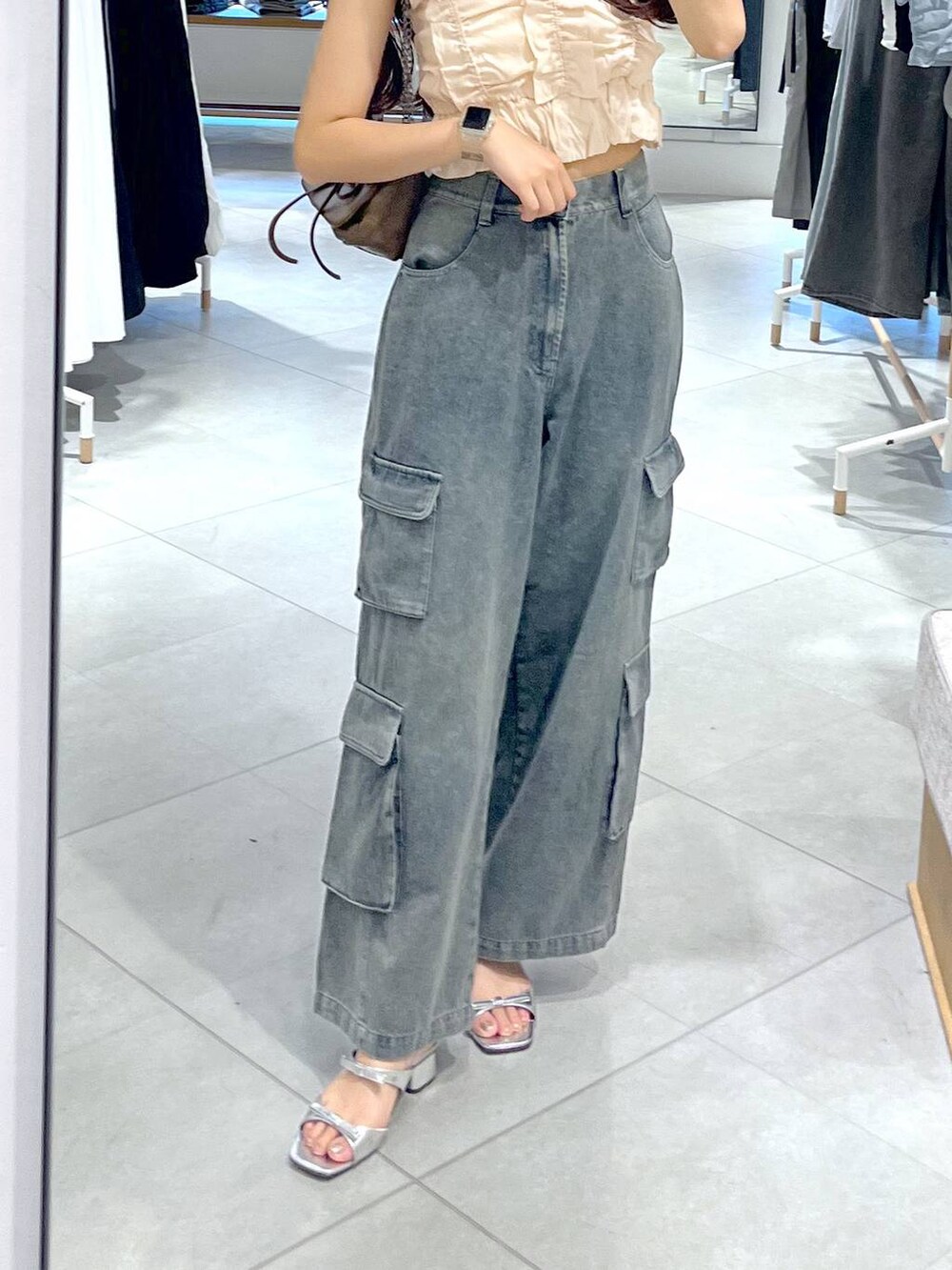 シルバー系のサンダル、ホワイト系のキャミソール、ブルー系のデニムパンツを着用したレディースの夏コーディネートの4枚目の写真