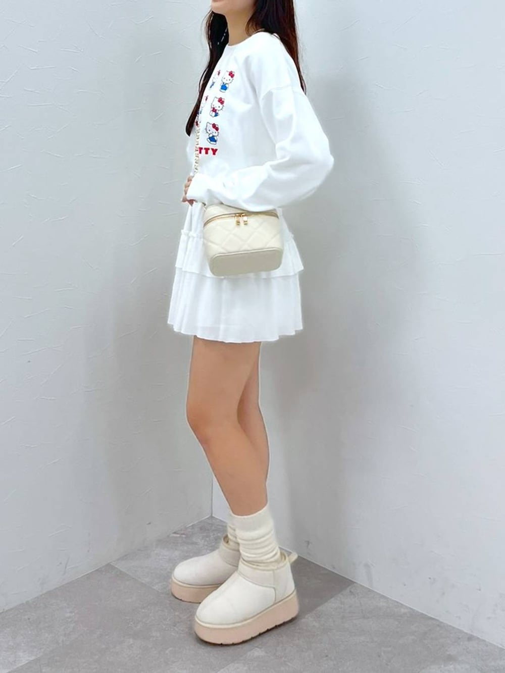 ホワイト系のTシャツ/カットソー、ホワイト系のショルダーバッグ、ホワイト系のブーツを着用したレディースの秋コーディネートの7枚目の写真