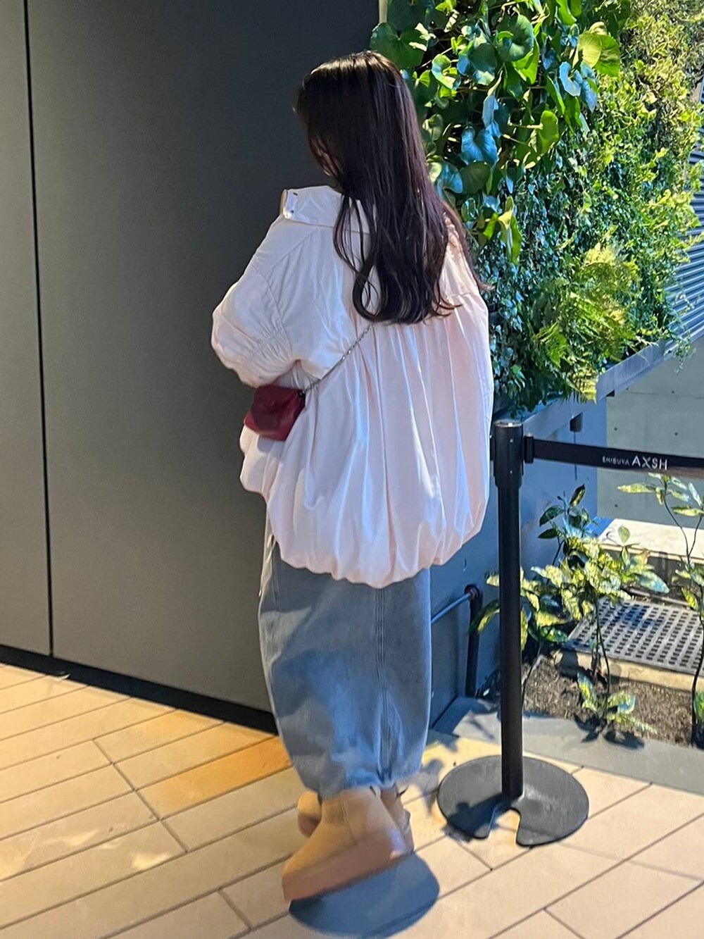 ホワイト系のTシャツ/カットソー、ピンク系のブルゾン、ベージュ系のブーツを着用したレディースの秋コーディネートの4枚目の写真