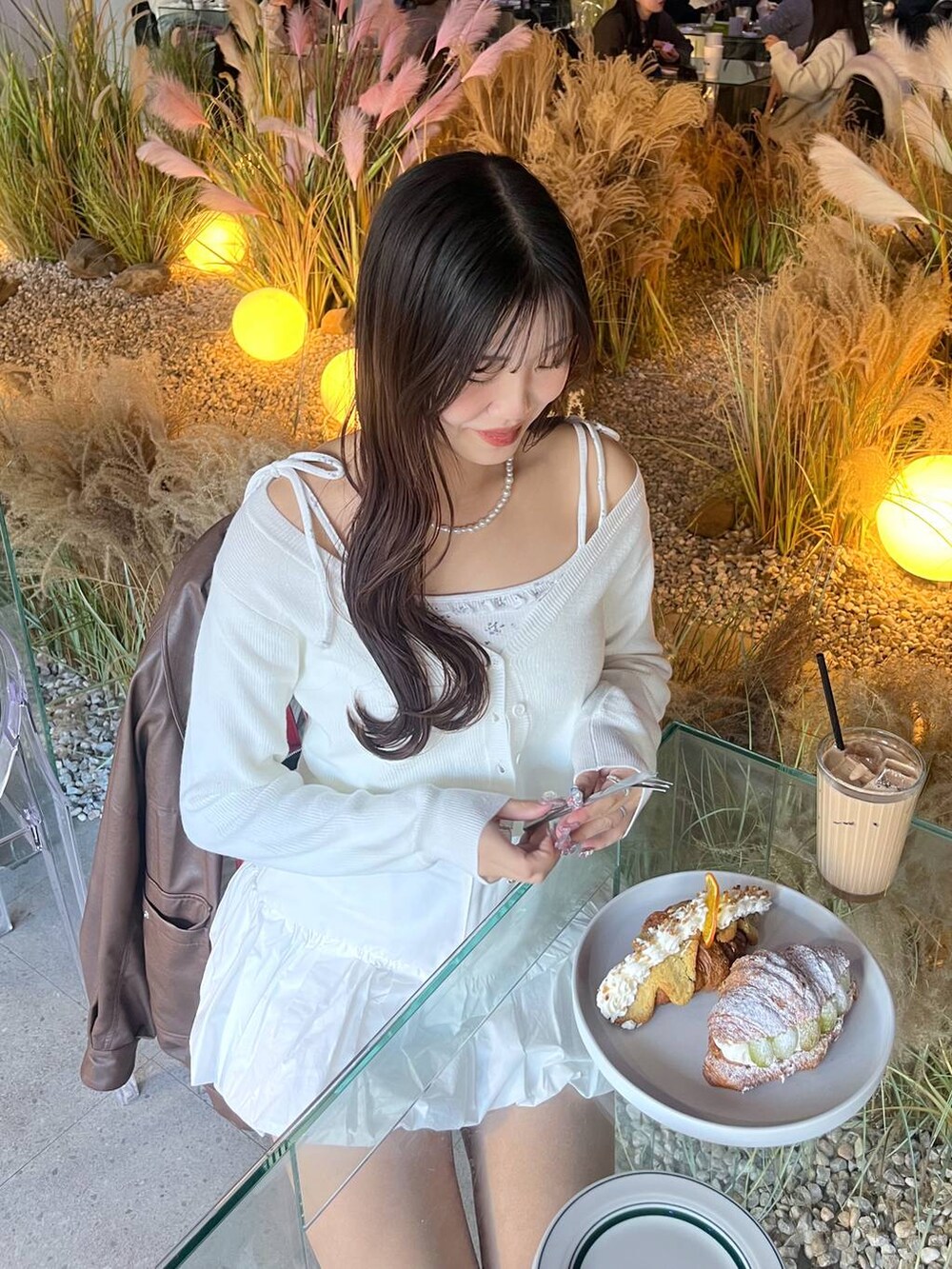 ホワイト系のスカート、ホワイト系のカーディガン/ボレロを着用したレディースの冬コーディネートの4枚目の写真