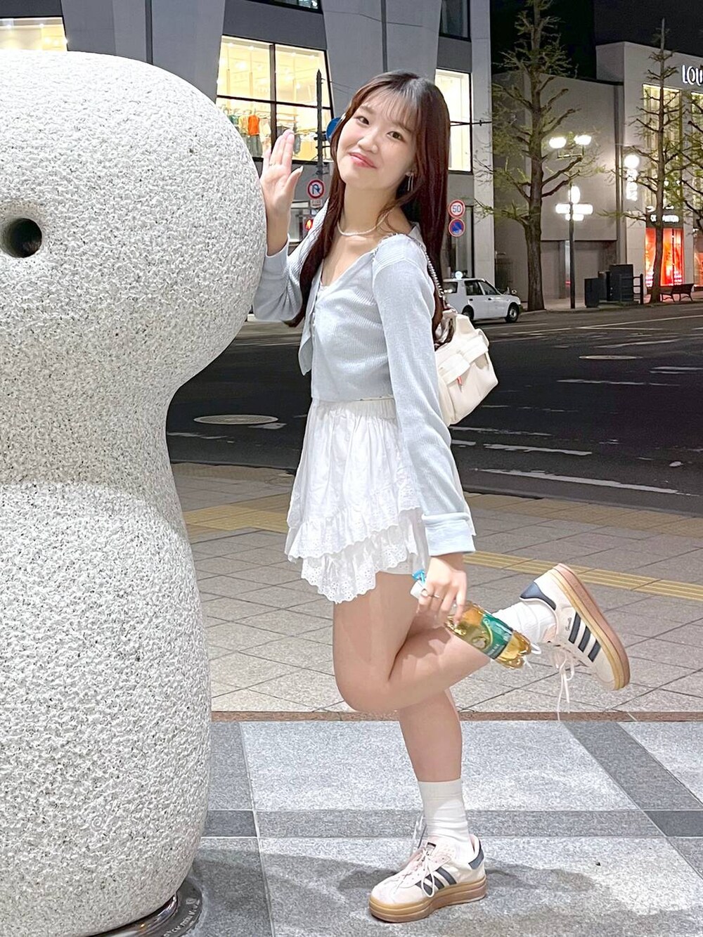 ホワイト系のキャミソール、ホワイト系のショルダーバッグ、ブルー系のカーディガン/ボレロを着用したレディースの春コーディネートの5枚目の写真