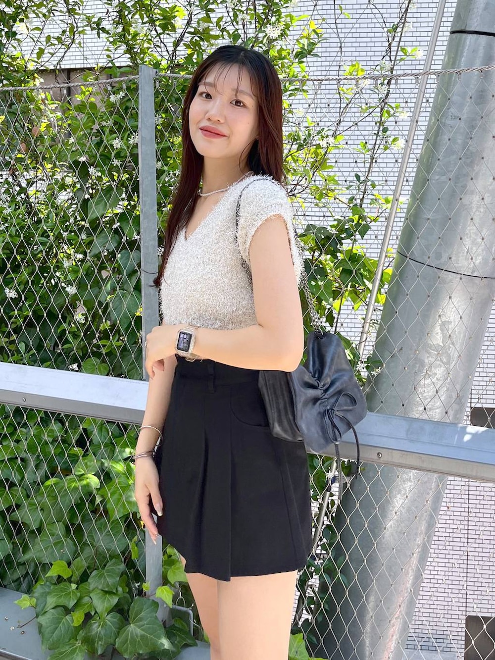 ブラック系のスカート、ホワイト系のキャミソール、ホワイト系のサンダルを着用したレディースの夏コーディネートの7枚目の写真