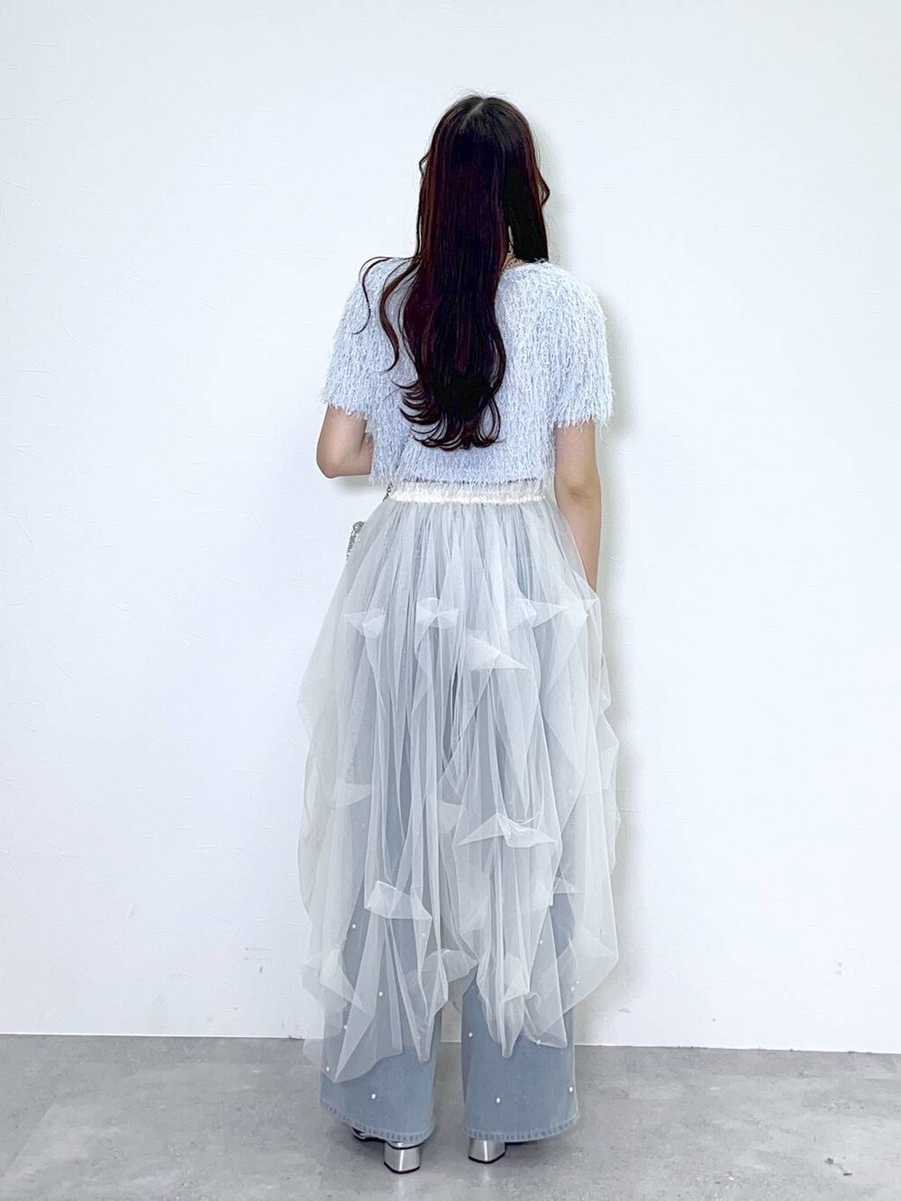 シルバー系のショルダーバッグ、ブルー系のデニムパンツ、ホワイト系のキャミソールを着用したレディースの春コーディネートの4枚目の写真