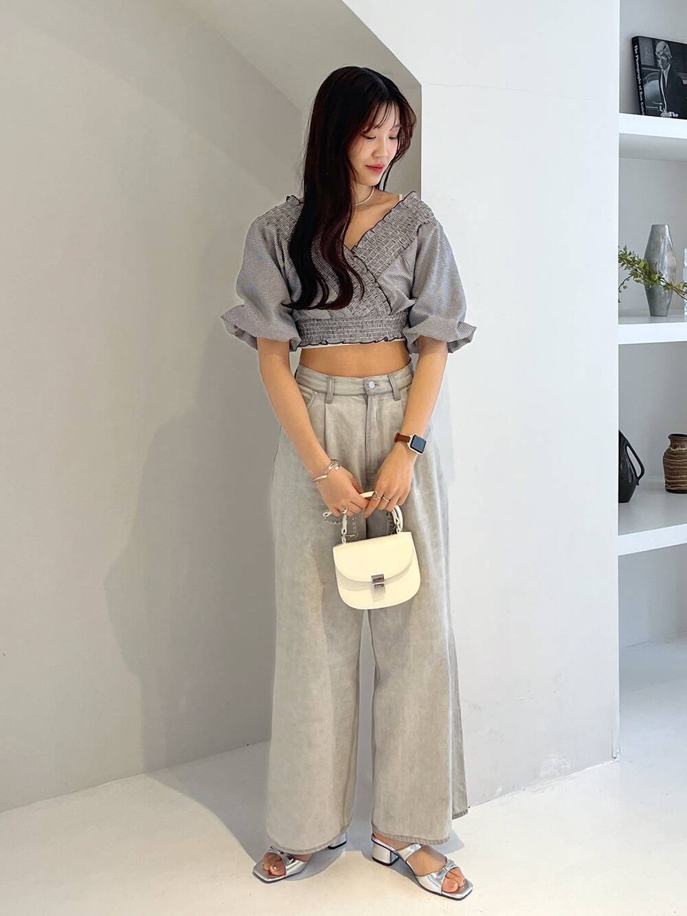 シルバー系のサンダル、ホワイト系のキャミソール、グレー系のデニムパンツを着用したレディースの春コーディネートの4枚目の写真