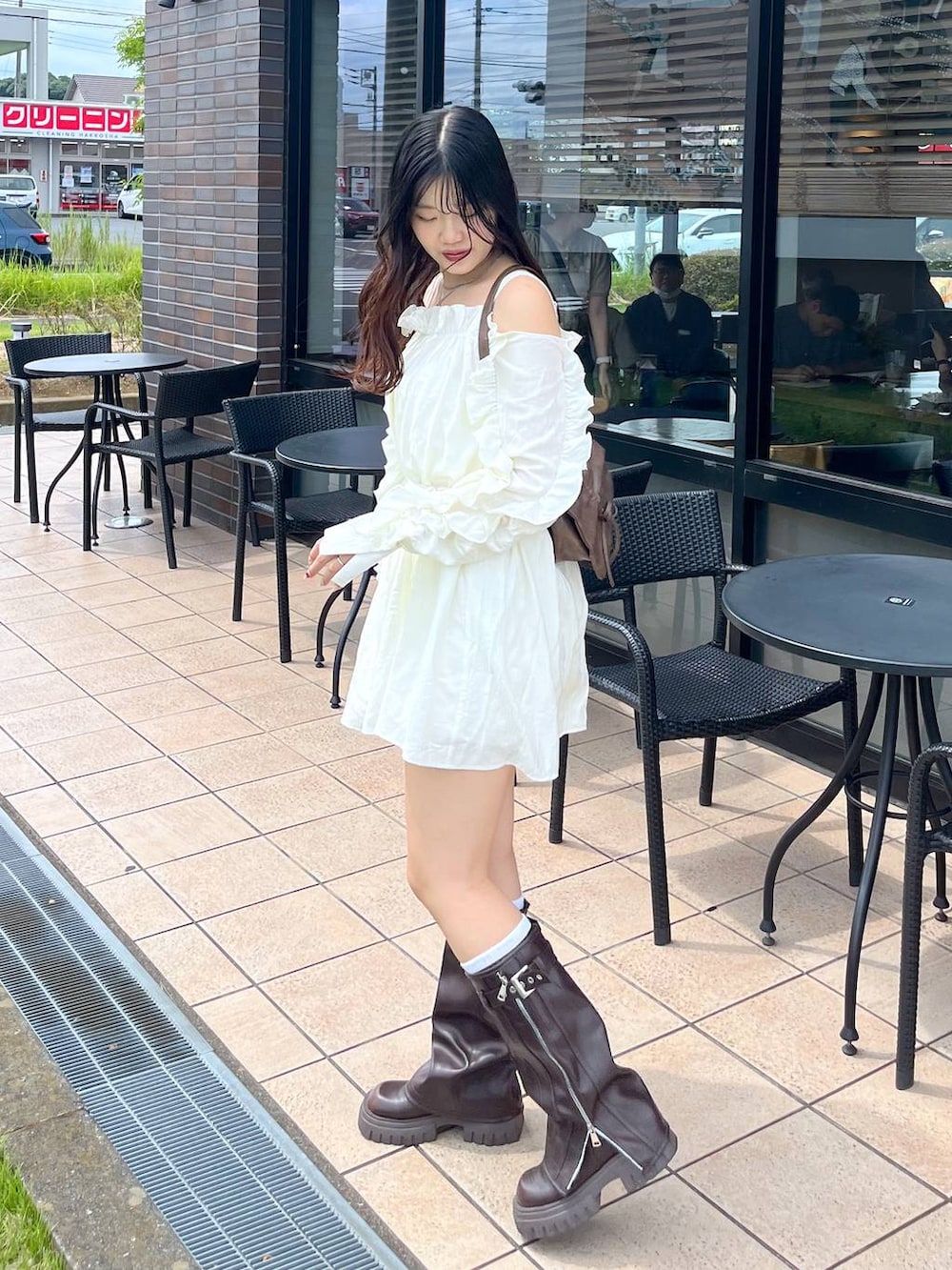 ブラウン系のショルダーバッグ、ブラウン系のブーツ、ホワイト系のキャミソールを着用したレディースの夏コーディネートの3枚目の写真