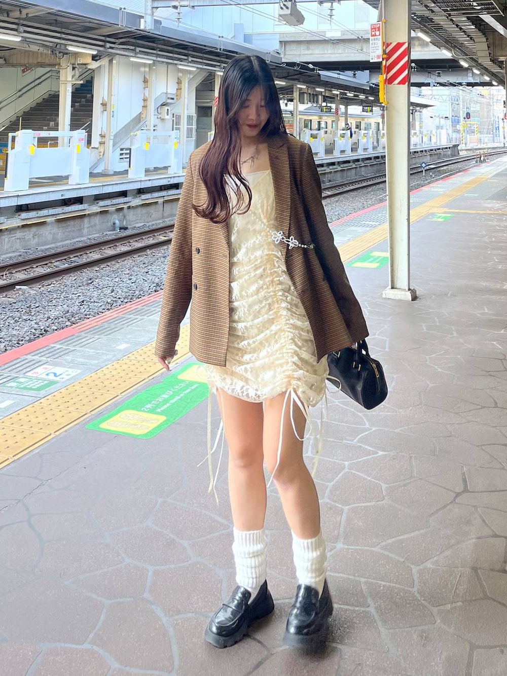 ホワイト系のキャミソール、ベージュ系のワンピース、ブラック系のローファーを着用したレディースの春コーディネートの4枚目の写真