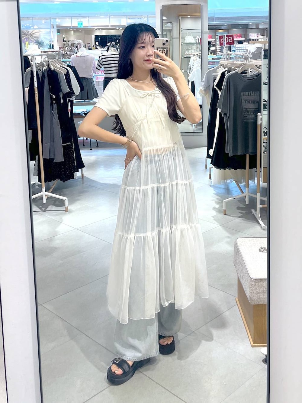 ホワイト系のワンピース、ホワイト系のキャミソール、ブルー系のデニムパンツを着用したレディースの夏コーディネートの2枚目の写真