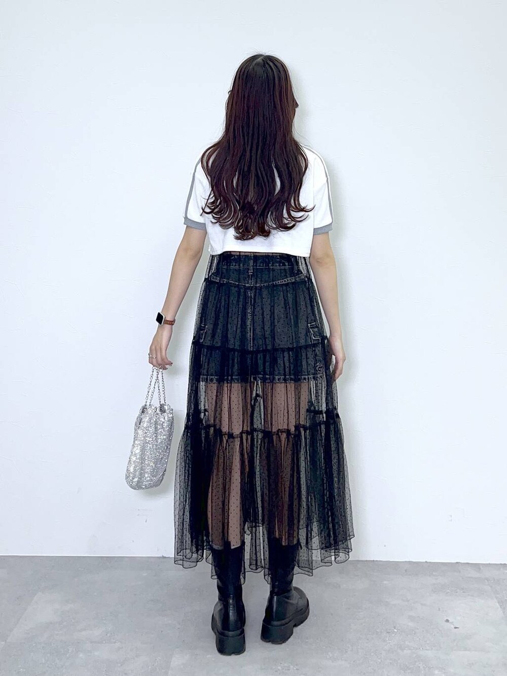 ブラック系のワンピース、ブラック系のブーツ、ブラック系のデニムスカートを着用したレディースの春コーディネートの3枚目の写真