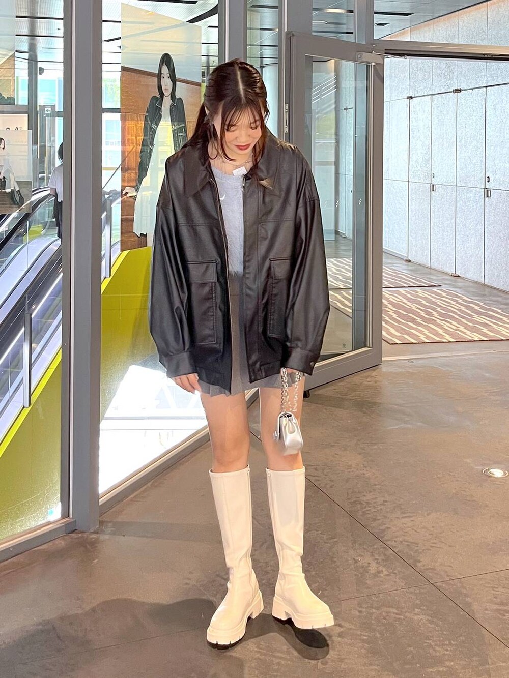 グレー系のスカート、ブルー系のカーディガン/ボレロ、ホワイト系のブーツを着用したレディースの秋コーディネートの7枚目の写真