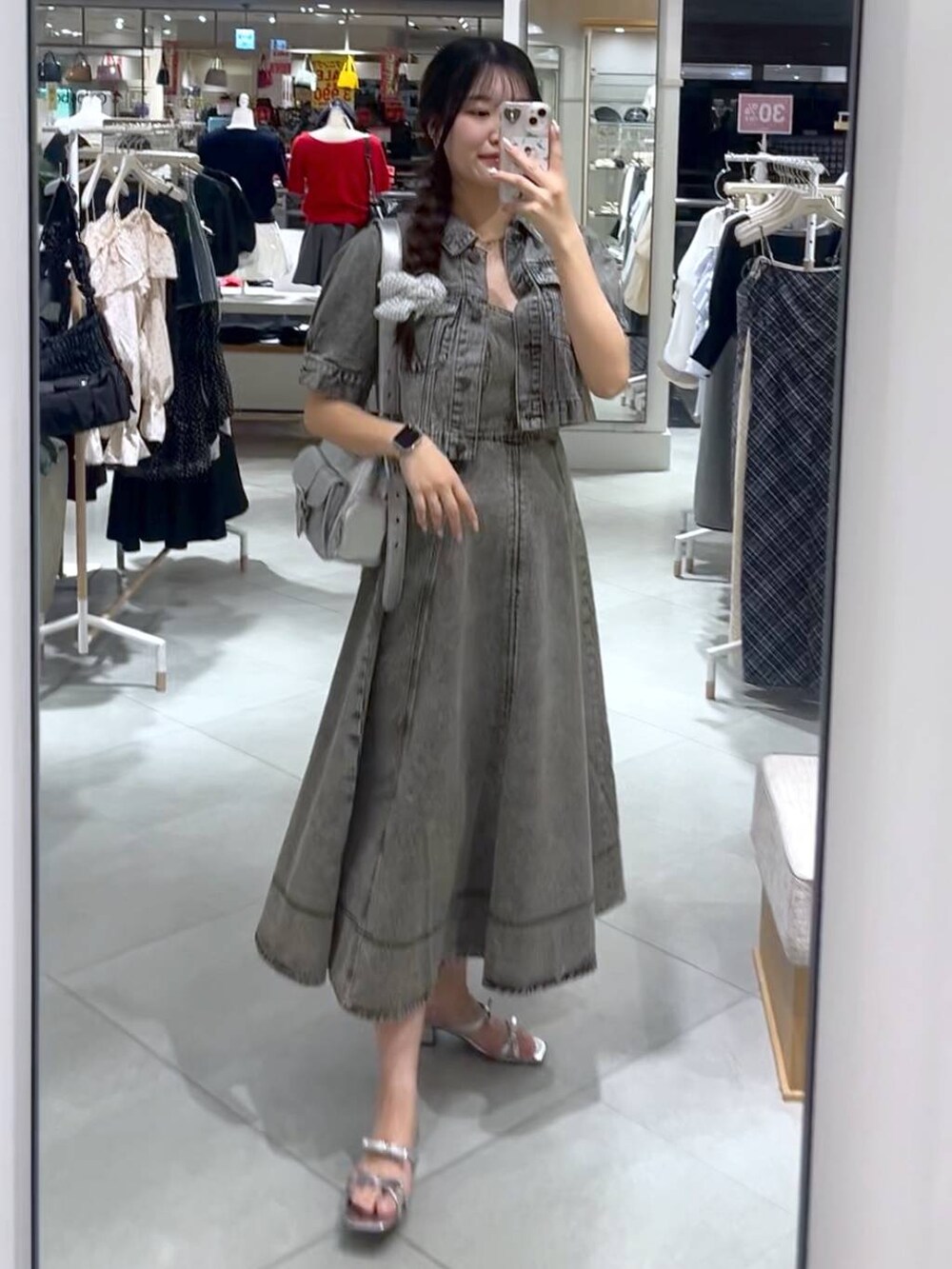 シルバー系のショルダーバッグ、グレー系のデニムジャケット、グレー系のワンピースを着用したレディースの春コーディネートの2枚目の写真