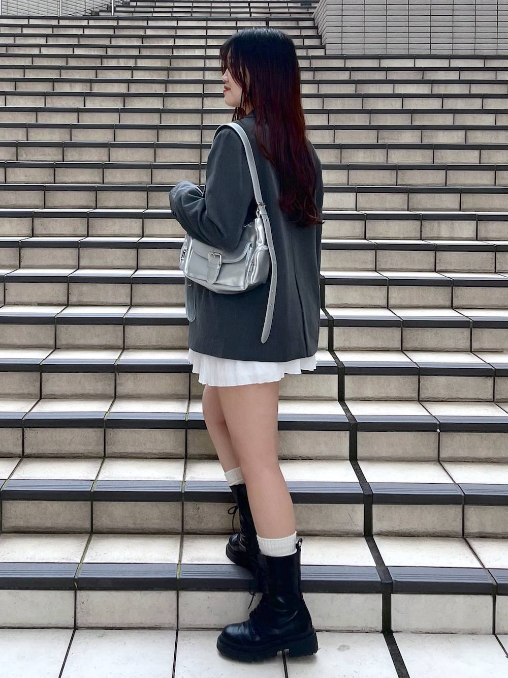 ホワイト系のキャミソール、ホワイト系のスカート、ブラック系のブーツを着用したレディースの春コーディネートの4枚目の写真