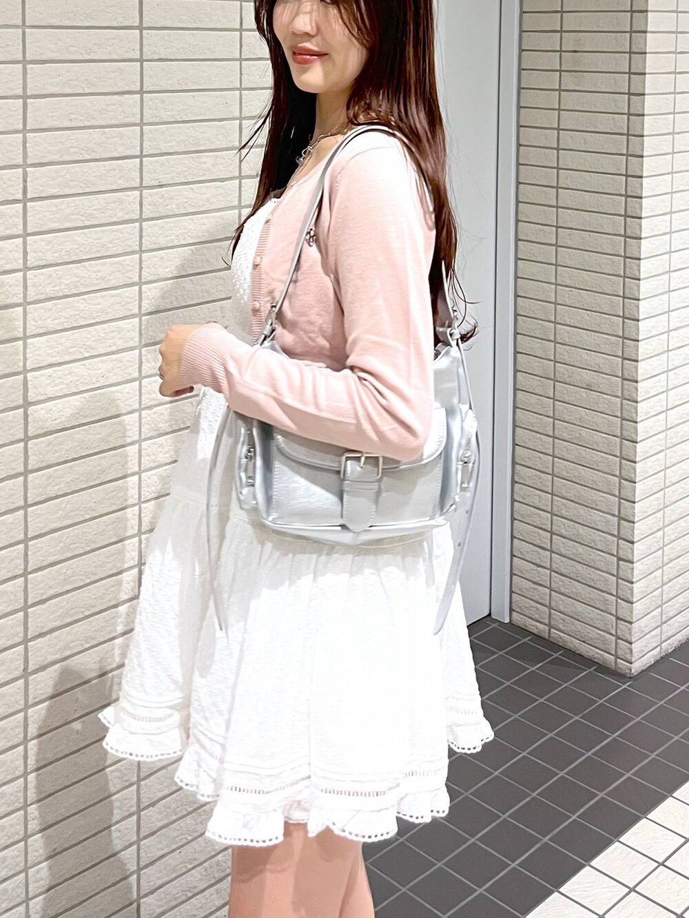 ホワイト系のキャミソール、ピンク系のカーディガン/ボレロ、ブラック系のブーツを着用したレディースの春コーディネートの4枚目の写真