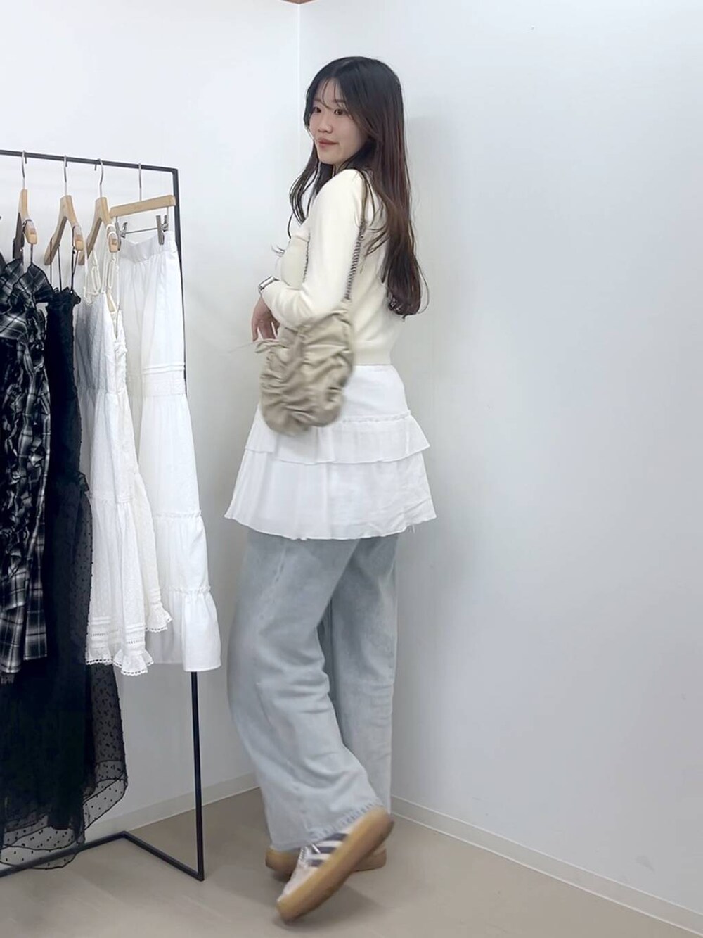 ホワイト系のキャミソール、ブルー系のデニムパンツ、ホワイト系のスカートを着用したレディースの春コーディネートの8枚目の写真