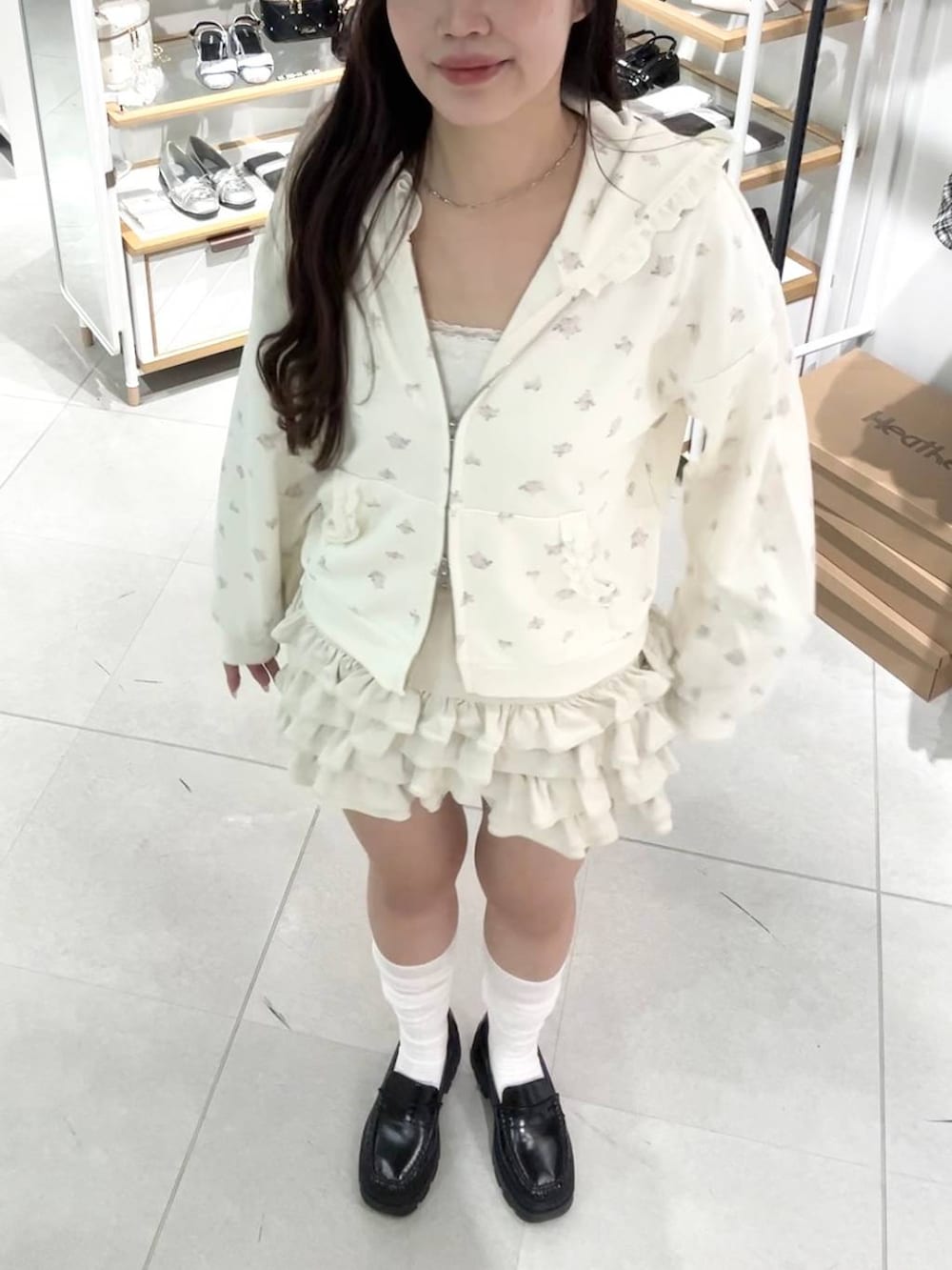 ブラック系のローファー、ホワイト系のパーカー、ホワイト系のスカートを着用したレディースの秋コーディネートの3枚目の写真