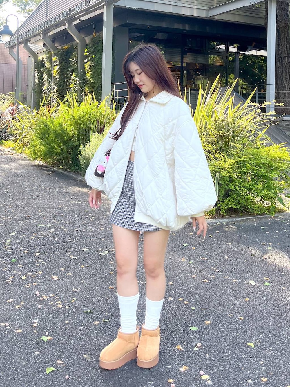 ブラウン系のショルダーバッグ、ホワイト系のTシャツ/カットソー、ベージュ系のブーツを着用したレディースの秋コーディネートの2枚目の写真