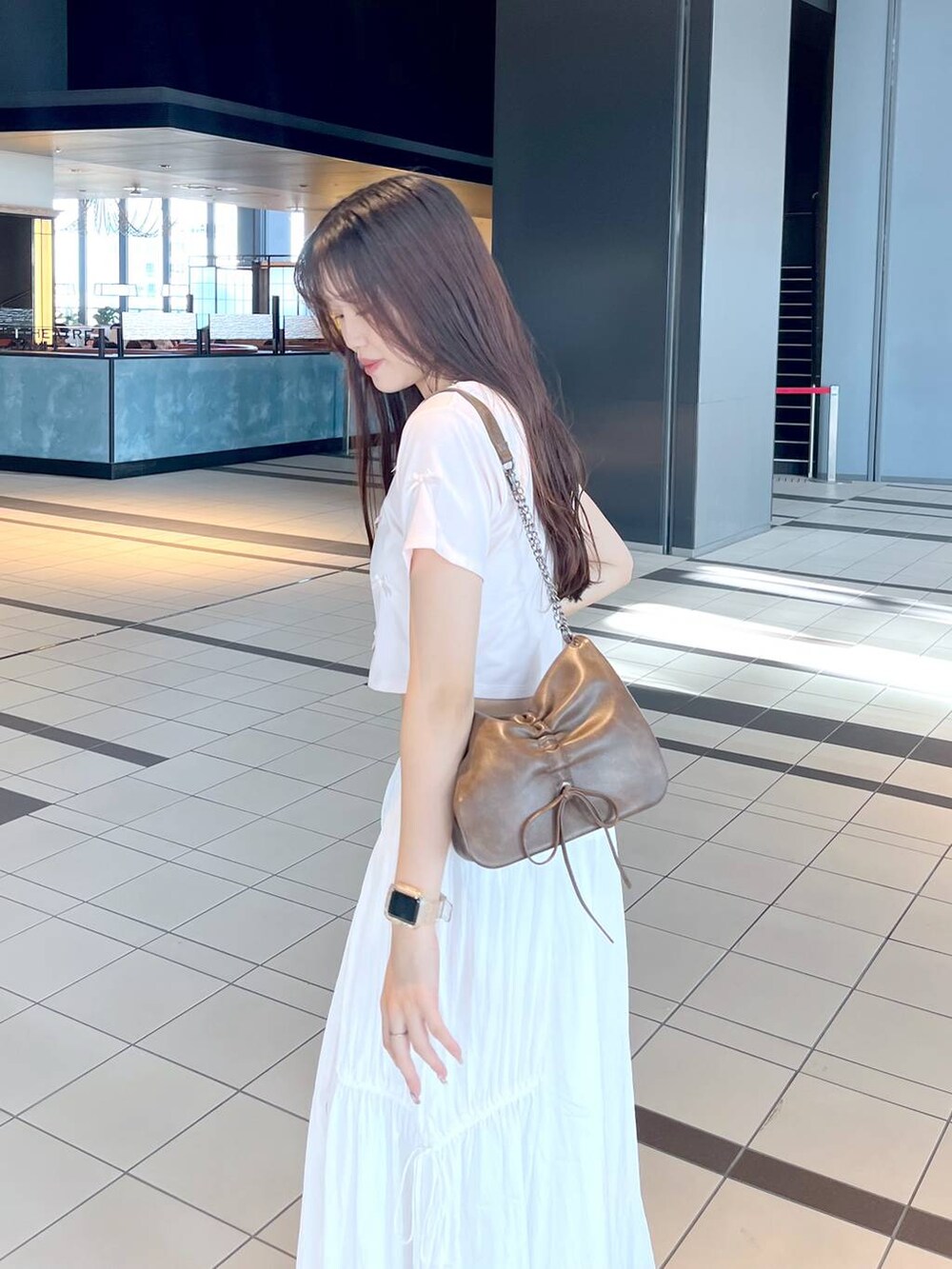 ピンク系のTシャツ/カットソー、ブラウン系のショルダーバッグ、ホワイト系のキャミソールを着用したレディースの春コーディネートの6枚目の写真