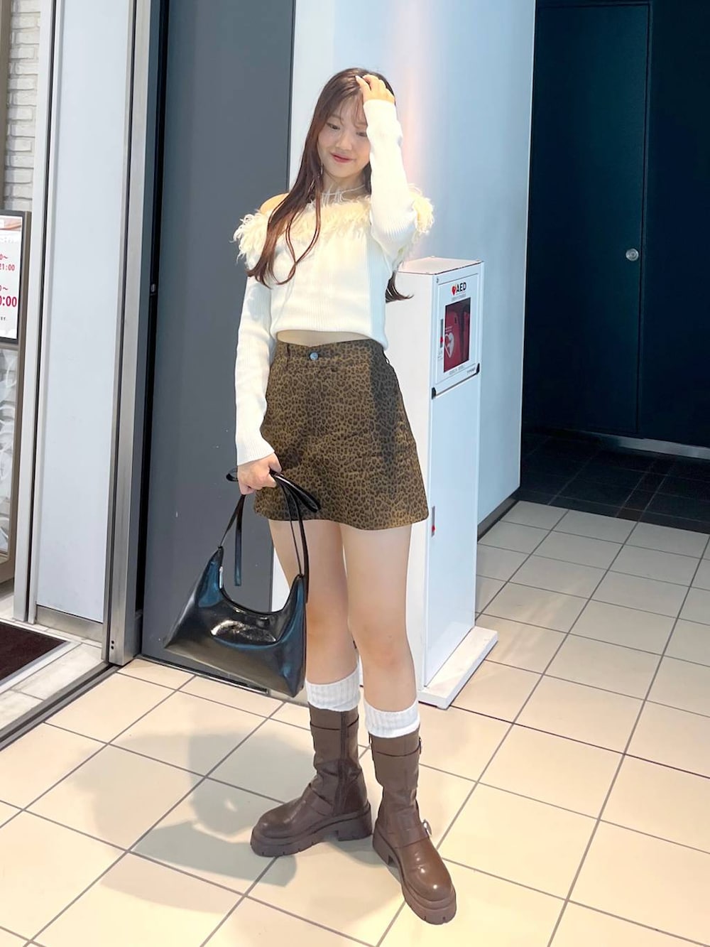 ブラウン系のブーツ、その他のスカート、ホワイト系のキャミソールを着用したレディースの秋コーディネートの2枚目の写真