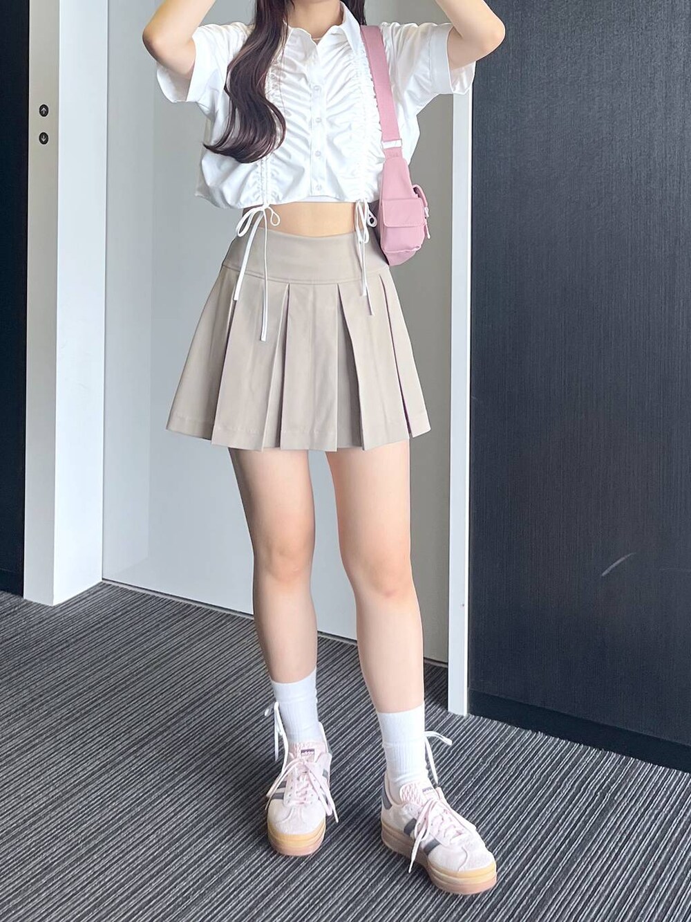 ピンク系のショルダーバッグ、ホワイト系のキャミソール、ベージュ系のスカートを着用したレディースの夏コーディネートの7枚目の写真