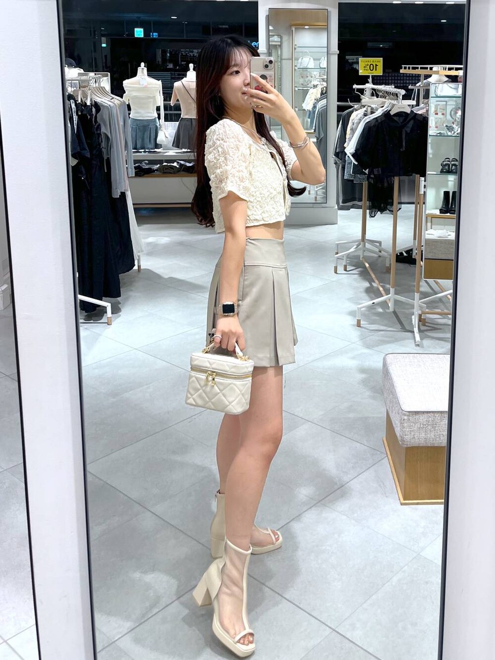 ホワイト系のカーディガン/ボレロ、ホワイト系のキャミソール、ホワイト系のショルダーバッグを着用したレディースの夏コーディネートの4枚目の写真