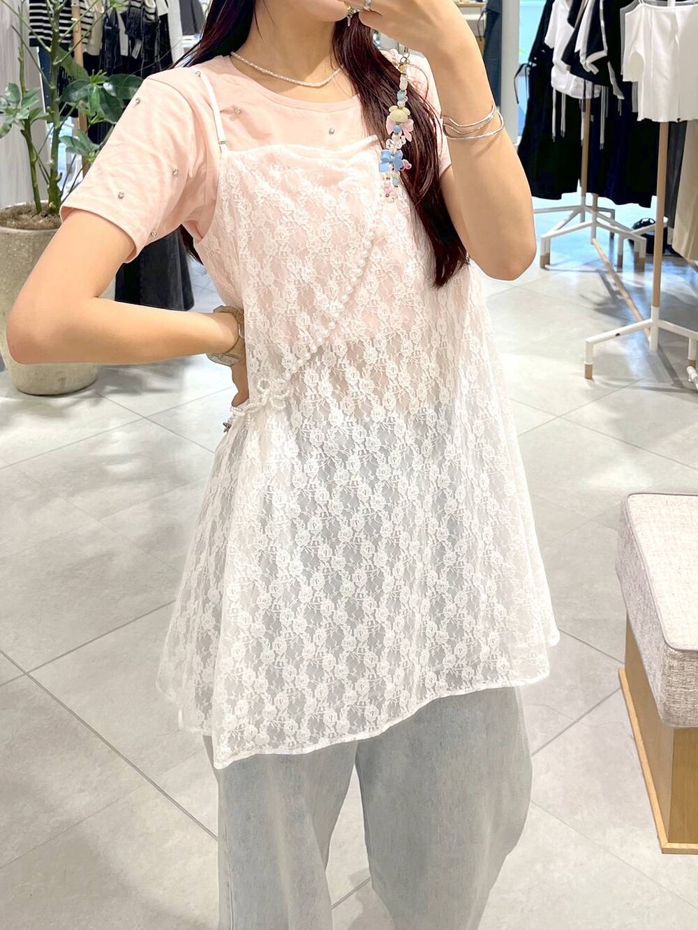 シルバー系のサンダル、ホワイト系のキャミソール、ブルー系のデニムパンツを着用したレディースの春コーディネートの7枚目の写真