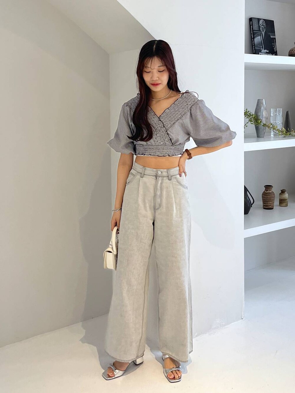 シルバー系のサンダル、ホワイト系のキャミソール、グレー系のデニムパンツを着用したレディースの春コーディネートの2枚目の写真