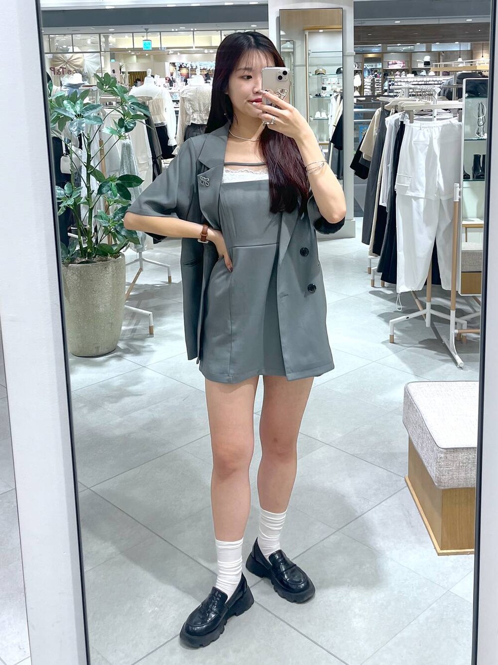 グレー系のワンピース、ブラック系のローファー、ホワイト系のキャミソールを着用したレディースの夏コーディネートの2枚目の写真