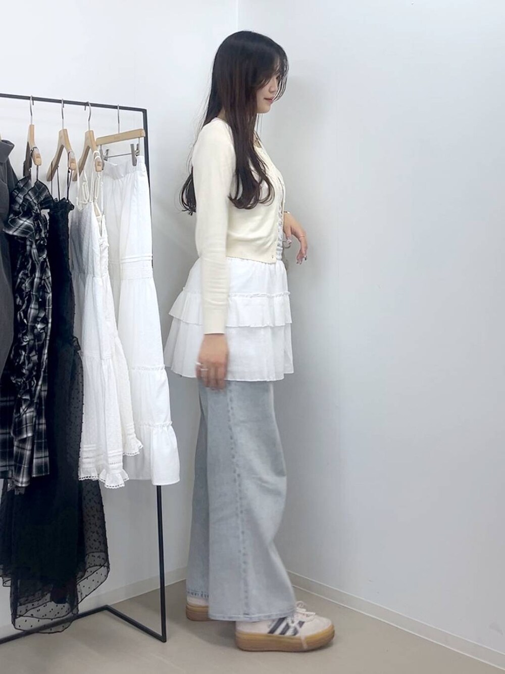 ホワイト系のキャミソール、ブルー系のデニムパンツ、ホワイト系のスカートを着用したレディースの春コーディネートの4枚目の写真
