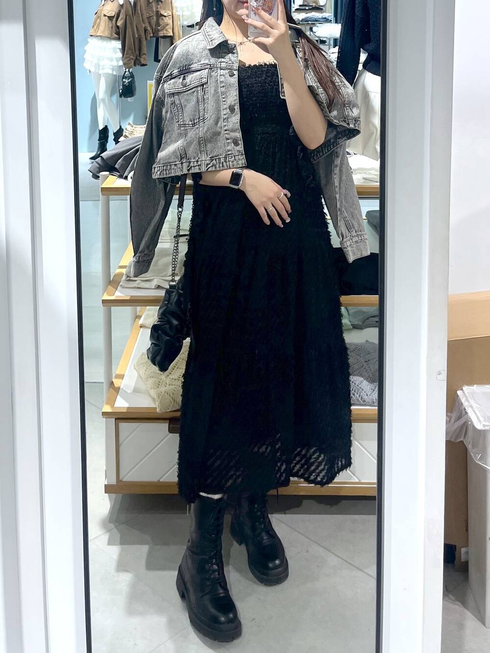 ホワイト系のキャミソール、ブラック系のショルダーバッグ、ブラック系のブーツを着用したレディースの春コーディネートの6枚目の写真