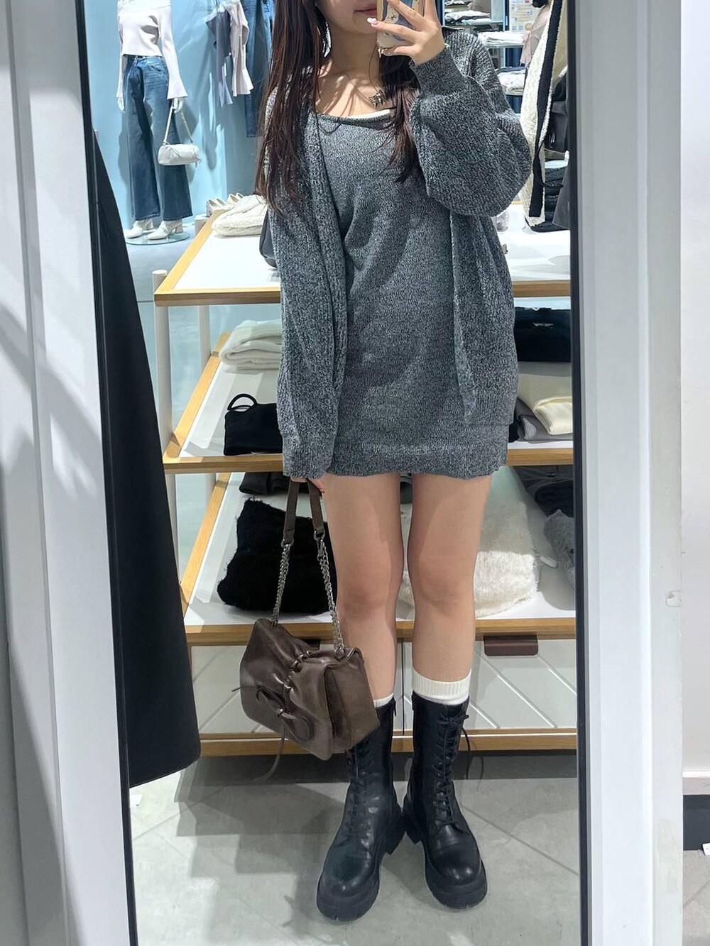 ブラウン系のショルダーバッグ、ブラック系のブーツ、ホワイト系のTシャツ/カットソーを着用したレディースの冬コーディネートの5枚目の写真