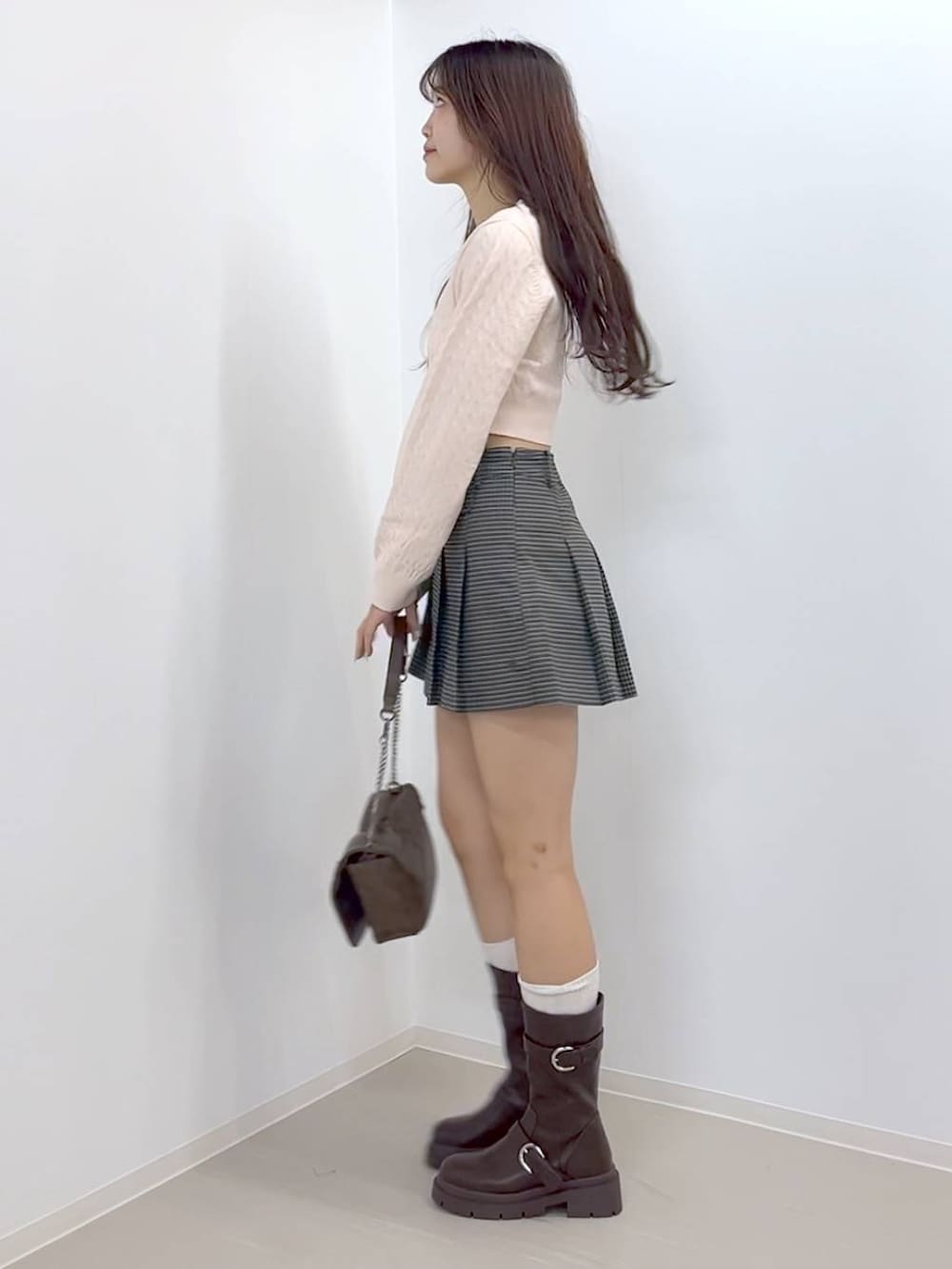 ブラウン系のショルダーバッグ、ブラウン系のブーツ、ホワイト系のキャミソールを着用したレディースの秋コーディネートの3枚目の写真