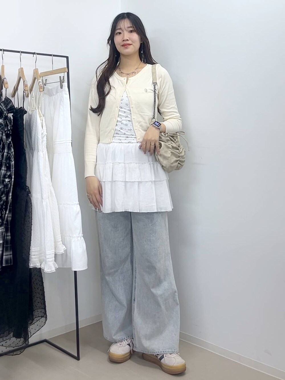 ホワイト系のキャミソール、ブルー系のデニムパンツ、ホワイト系のスカートを着用したレディースの春コーディネートの3枚目の写真