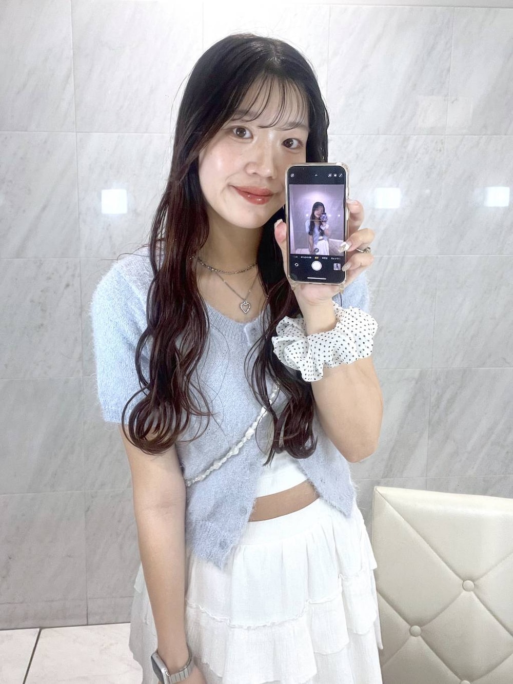 ホワイト系のキャミソール、ホワイト系のスカート、ブルー系のカーディガン/ボレロを着用したレディースの春コーディネートの3枚目の写真