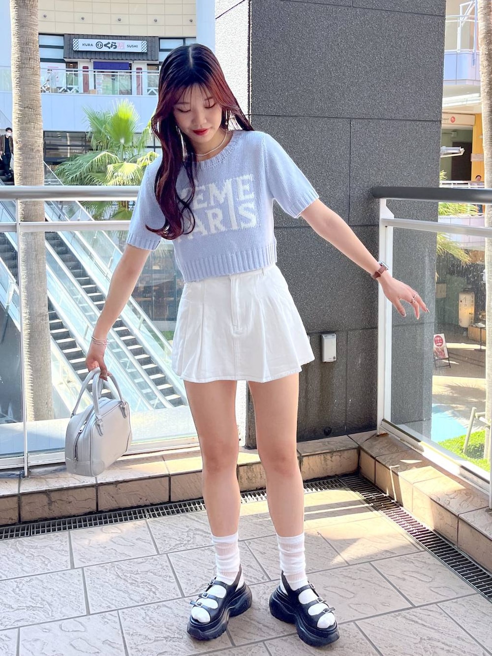 ブルー系のニット/セーター、ホワイト系のキャミソール、ブラック系のサンダルを着用したレディースの夏コーディネートの4枚目の写真